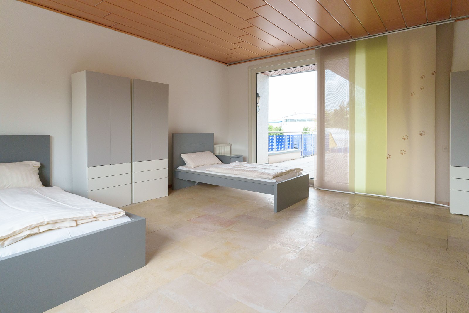 /Ansprechendes Foto eines sauberen, funktional eingerichteten Zimmers mit zwei Einzelbetten.